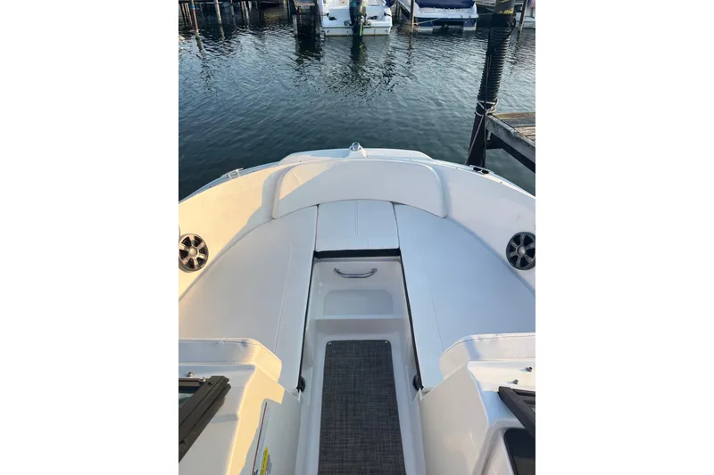 Slide: The Image of 2020 Sea Ray SPX 210 boat interior with white seating, docked at marina. - 18