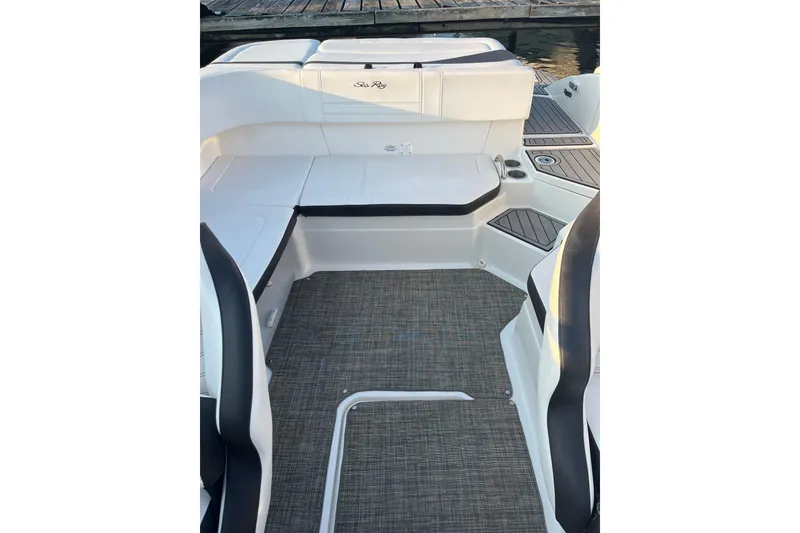 Slide: The Image of 2020 Sea Ray SPX 210 boat interior with cushioned seating and carpeted flooring. - 19
