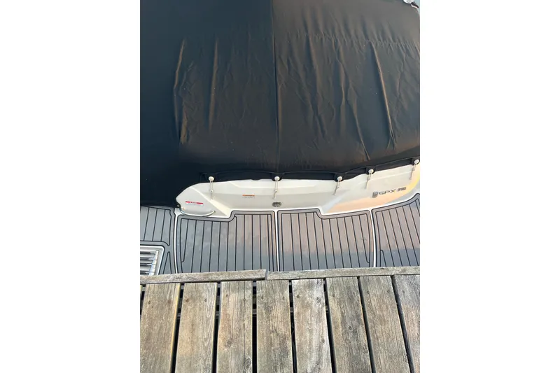Slide: The Image of 2020 Sea Ray SPX 210 boat with black cover and wooden dock. - 23