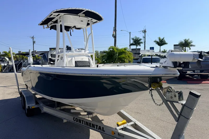 Slide: The Image of 2021 Tidewater 210 LXF boat on trailer, parked outdoors under clear sky. - 6