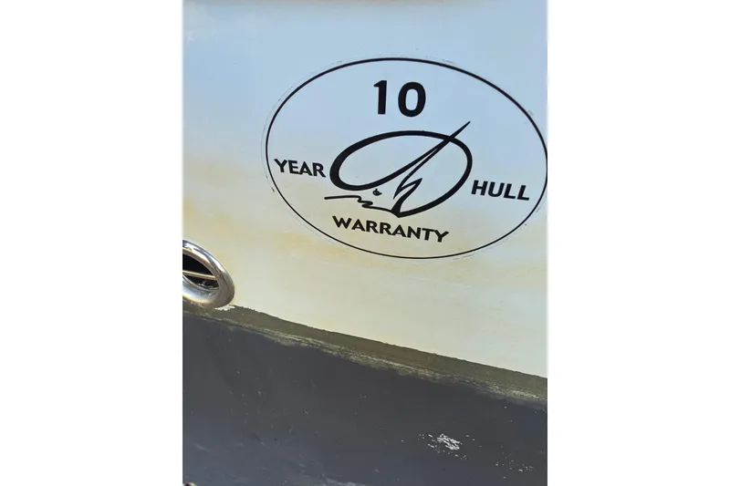 Slide: The Image of 2022 Sailfish 220 WAC boat under shelter, side view with railing and cabin details. - 11