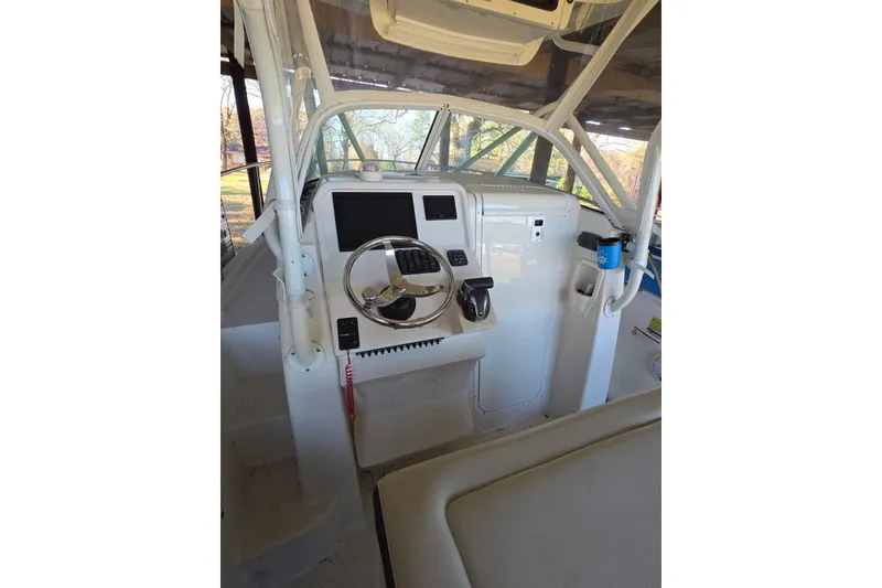 Slide: The Image of 2022 Sailfish 220 WAC boat interior under a metal roof, showcasing helm and controls. - 13
