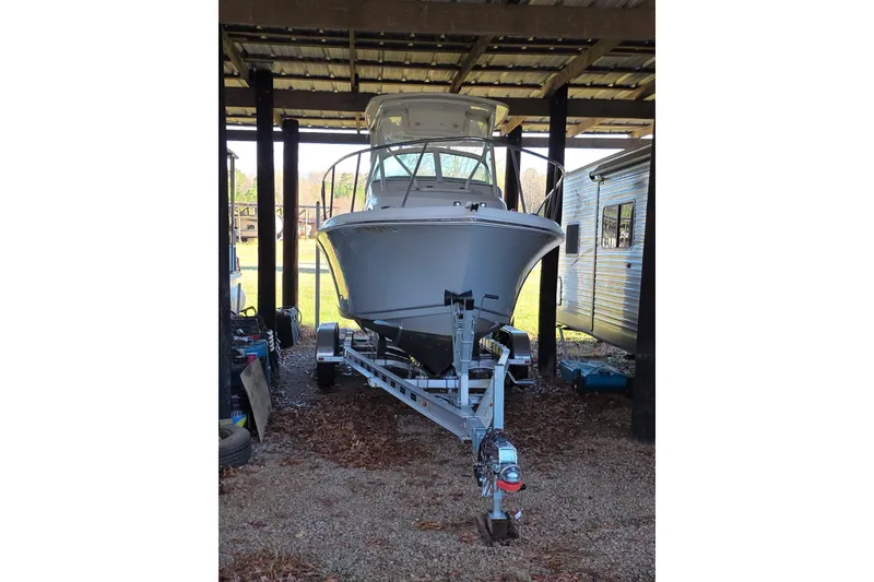 Slide: The Image of 2022 Sailfish 220 WAC boat on trailer under shelter, side view. - 2