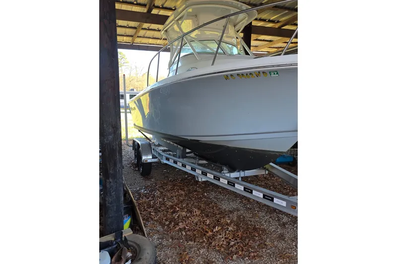 Slide: The Image of 2022 Sailfish 220 WAC boat on trailer, surrounded by autumn leaves. - 4
