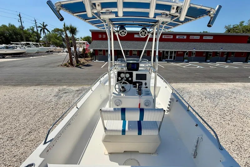 Slide: The Image of 2001 Sea Fox 215 Bay Fisher boat with center console and blue canopy in a marina setting. - 11