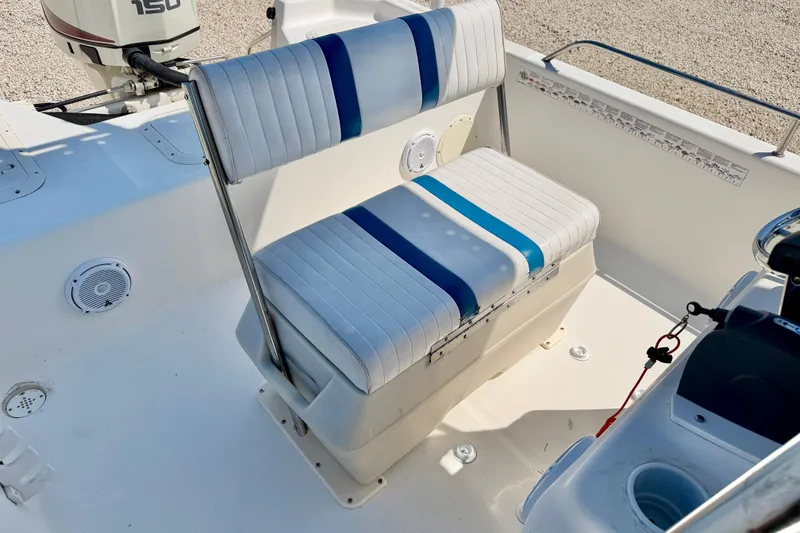 Slide: The Image of 2001 Sea Fox 215 Bay Fisher boat interior with striped seating and motor. - 19