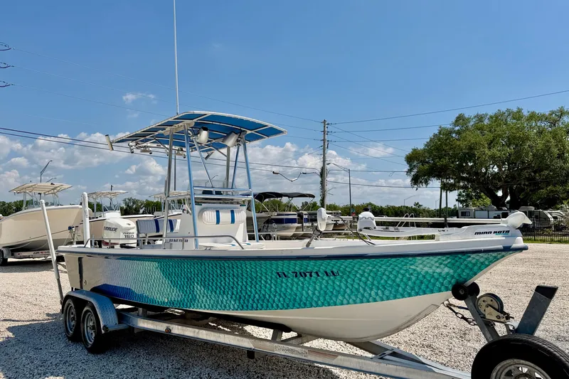 Slide: The Image of 2001 Sea Fox 215 Bay Fisher boat on trailer, vibrant blue-green hull, sunny day. - 3