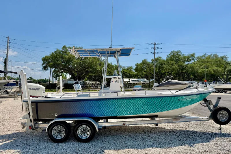 Slide: The Image of 2001 Sea Fox 215 Bay Fisher boat on trailer, featuring vibrant blue-green hull design. - 4