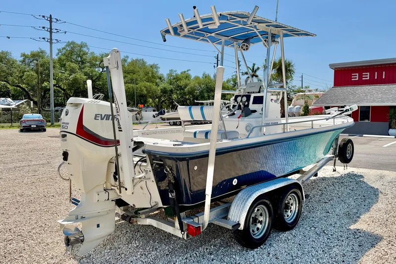 Slide: The Image of 2001 Sea Fox 215 Bay Fisher boat with Evinrude engine on trailer, parked outdoors. - 5