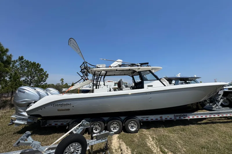 The Image of 2019 Everglades 435 Center Console boat on trailer, side view under clear blue sky. - 1
