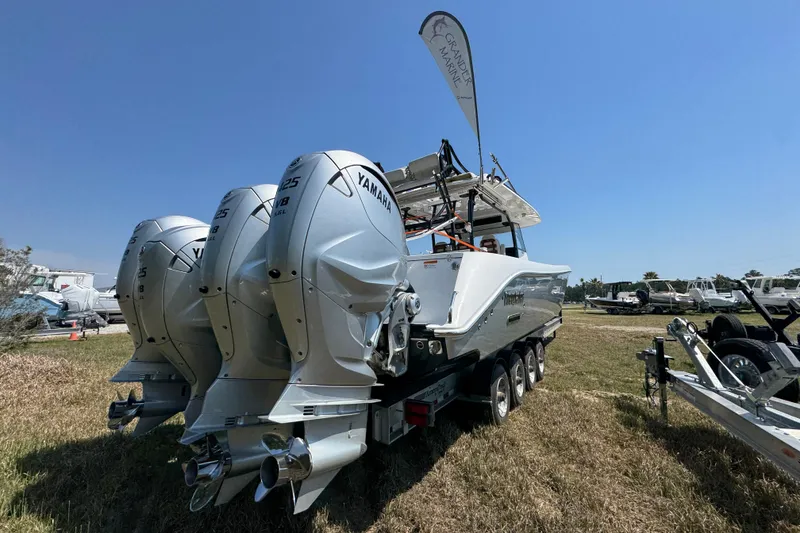 Slide: The Image of 2019 Everglades 435 Center Console boat with triple Yamaha engines on display outdoors. - 12