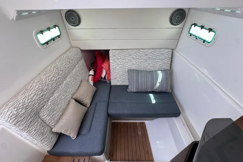 Slide: The Image of Interior cabin of 2019 Everglades 435 Center Console with cushioned seating and portholes. - 25