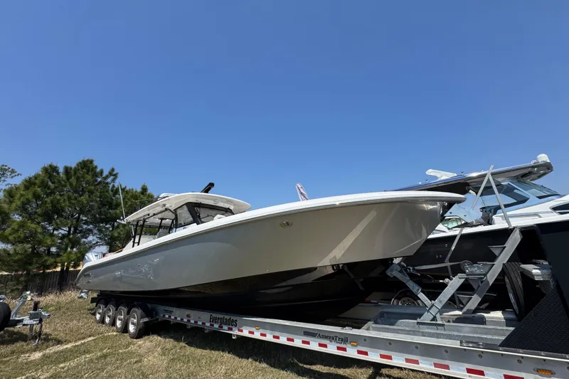 Slide: The Image of 2019 Everglades 435 Center Console boat on trailer under clear blue sky. - 3