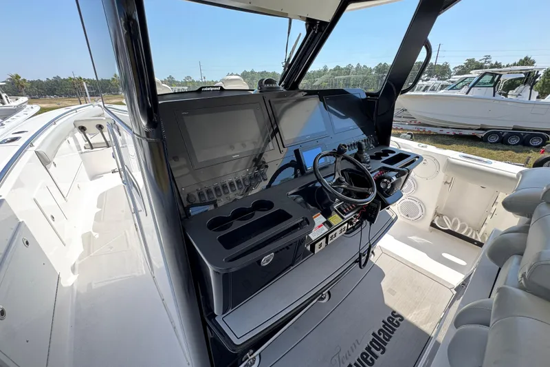 Slide: The Image of 2019 Everglades 435 Center Console boat cockpit with advanced navigation controls and seating. - 33