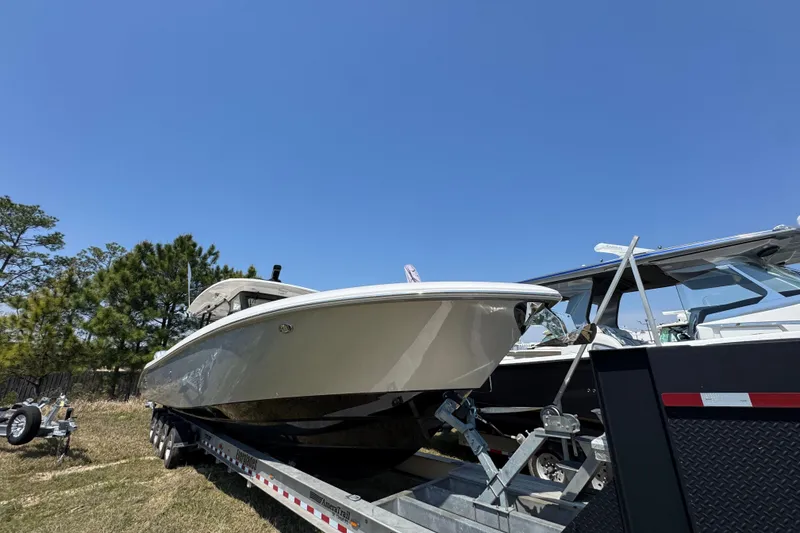 Slide: The Image of 2019 Everglades 435 Center Console boat on trailer under clear blue sky. - 4