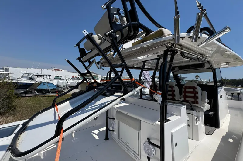 Slide: The Image of 2019 Everglades 435 Center Console boat with fishing rod holders and seating, docked outdoors. - 40