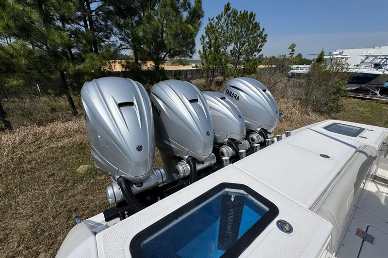 Slide: The Image of 2019 Everglades 435 Center Console with four Yamaha outboard engines, parked outdoors. - 46