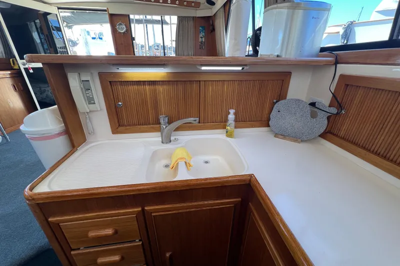 Slide: The Image of 1996 Riviera 4800 Sport Yacht kitchen with wooden cabinets and sink area. - 10