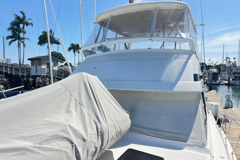 Slide: The Image of 1996 Riviera 4800 Sport Yacht docked at marina with covered equipment. - 101