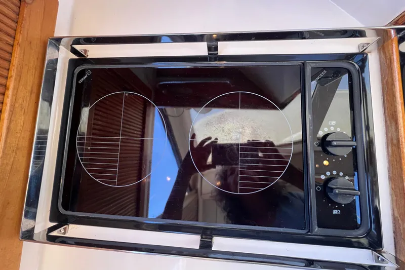 Slide: The Image of Ceramic cooktop on 1996 Riviera 4800 Sport Yacht, featuring dual burners and control knobs. - 11