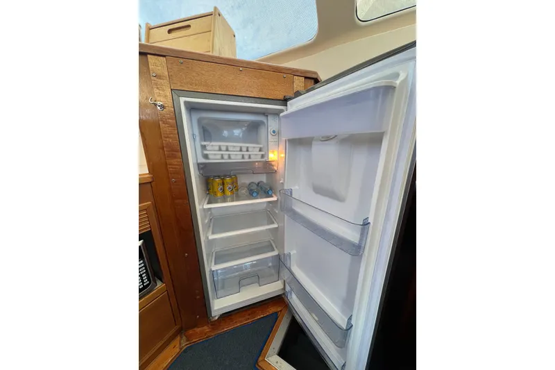 Slide: The Image of Open refrigerator inside 1996 Riviera 4800 Sport Yacht, stocked with drinks and ice tray. - 14