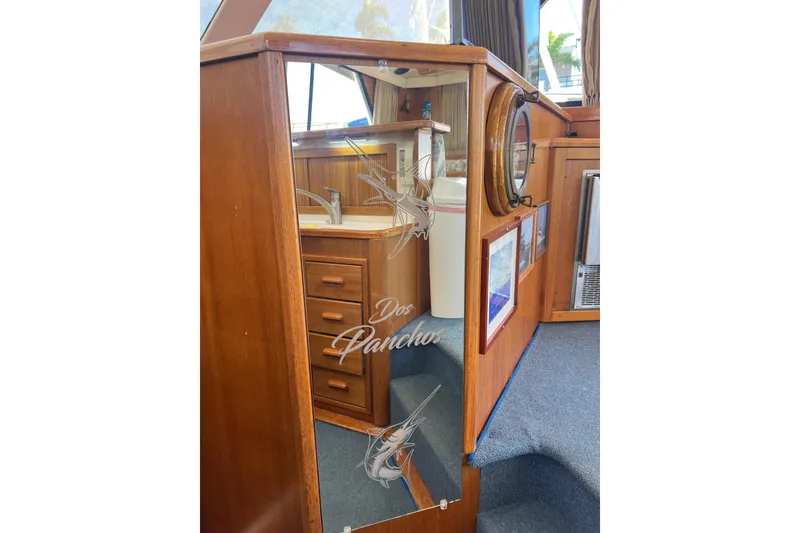 Slide: The Image of Interior of 1996 Riviera 4800 Sport Yacht with wooden cabinetry and etched glass panel. - 15