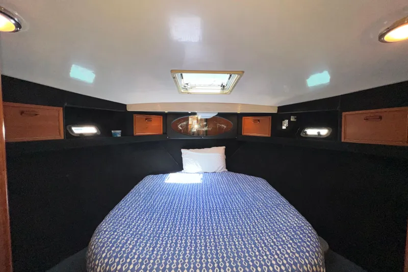 Slide: The Image of Cozy cabin interior of 1996 Riviera 4800 Sport Yacht with bed and storage. - 18