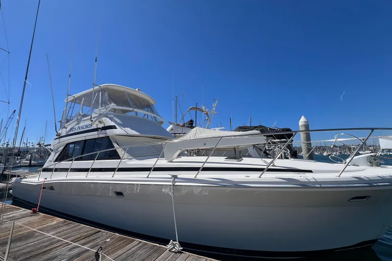 Slide: The Image of 1996 Riviera 4800 Sport Yacht docked at marina under clear blue sky. - 3