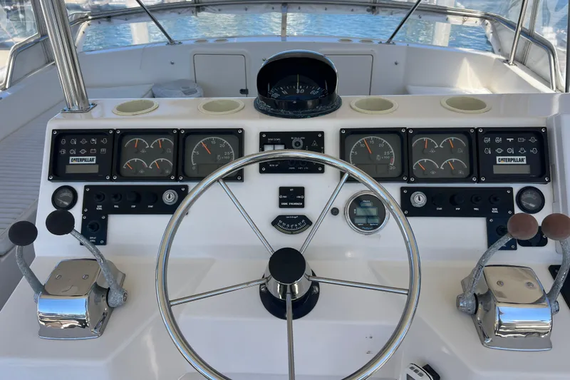 Slide: The Image of Cockpit of 1996 Riviera 4800 Sport Yacht with steering wheel and control panels. - 34