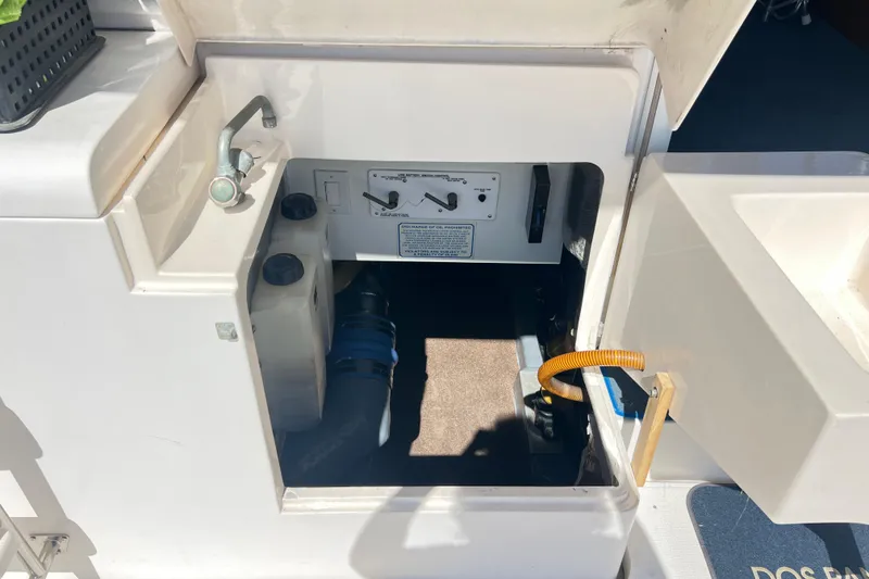 Slide: The Image of 1996 Riviera 4800 Sport Yacht engine compartment with control panel and storage. - 47