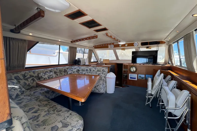 Slide: The Image of Interior of 1996 Riviera 4800 Sport Yacht with dining area and entertainment setup. - 5