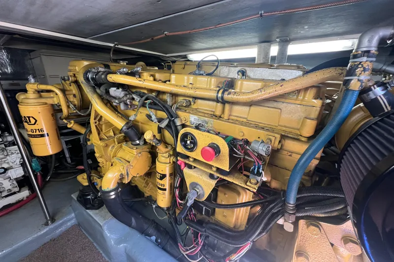Slide: The Image of Engine room of a 1996 Riviera 4800 Sport Yacht, featuring a yellow Caterpillar engine. - 51