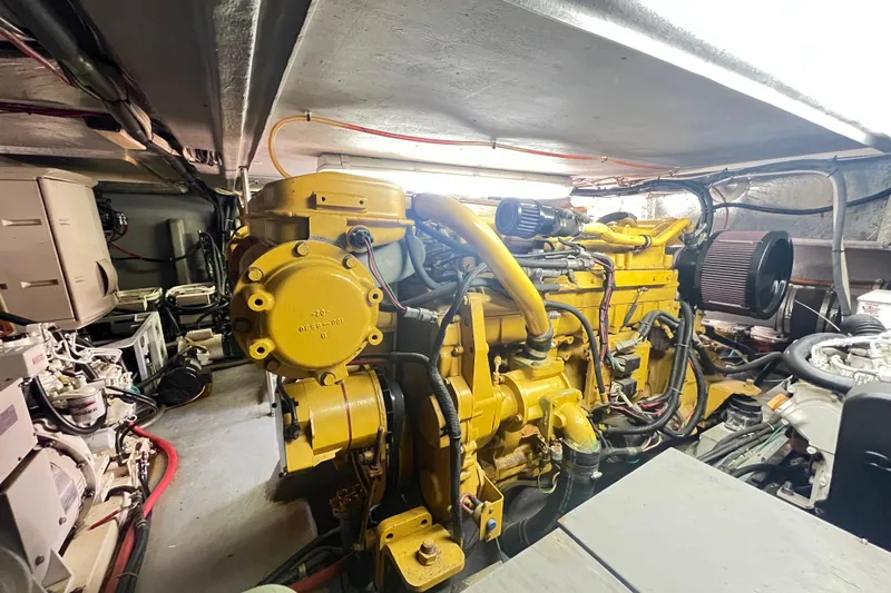 Slide: The Image of Engine room of a 1996 Riviera 4800 Sport Yacht, featuring a yellow engine. - 53