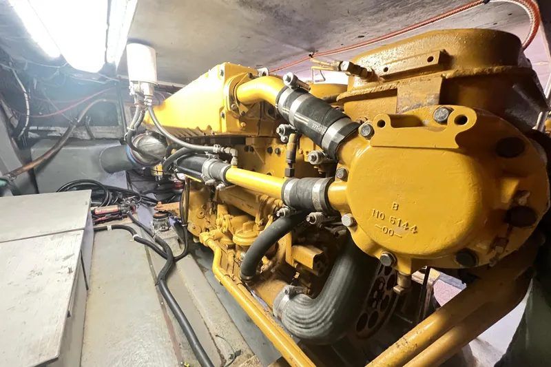 Slide: The Image of Engine room of 1996 Riviera 4800 Sport Yacht with visible yellow machinery components. - 54