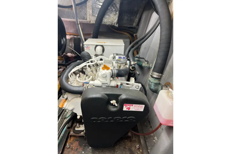 Slide: The Image of Engine compartment of a 1996 Riviera 4800 Sport Yacht, showcasing mechanical components and hoses. - 61