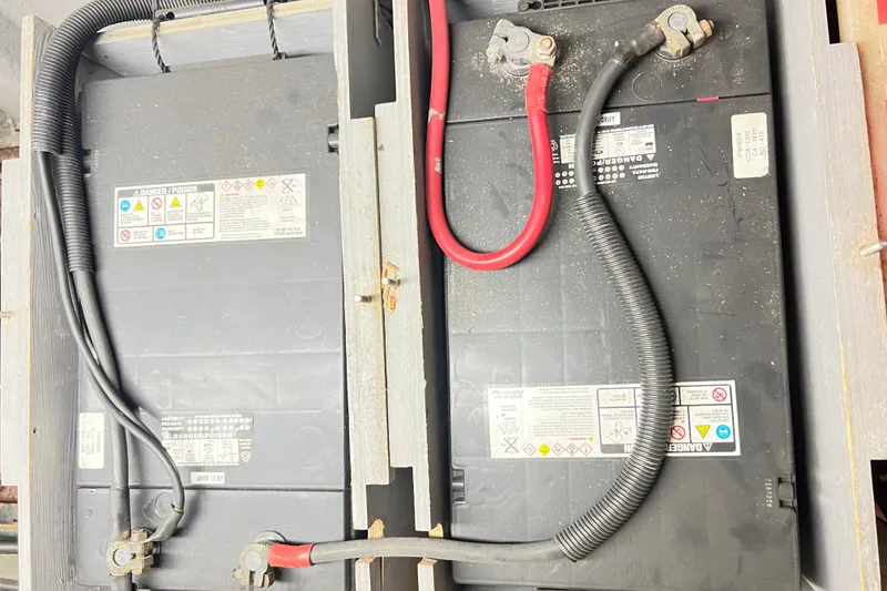 Slide: The Image of Battery compartment of a 1996 Riviera 4800 Sport Yacht with visible cables and warning labels. - 67