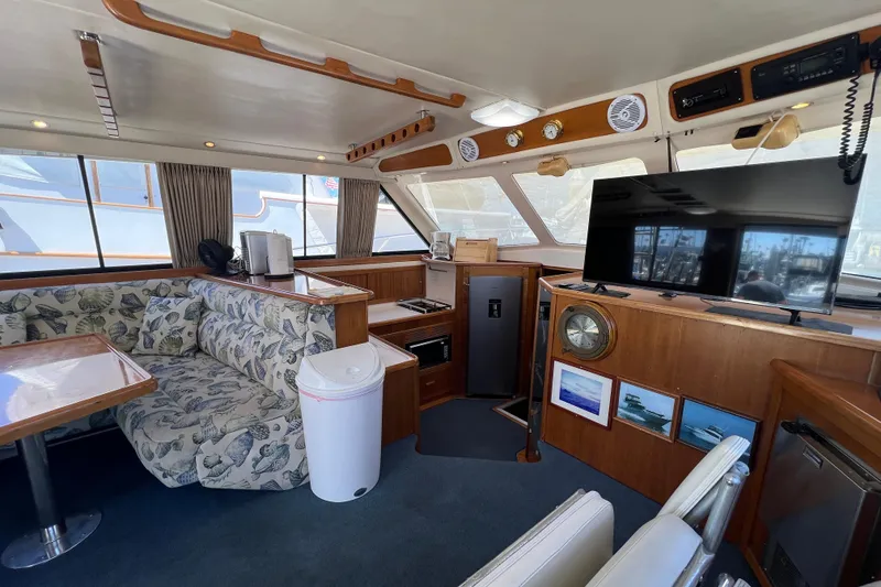 Slide: The Image of Interior of 1996 Riviera 4800 Sport Yacht with seating, TV, and nautical decor. - 7