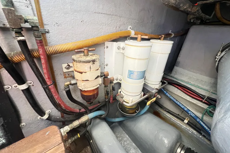 Slide: The Image of Engine room of 1996 Riviera 4800 Sport Yacht showing fuel filters and hoses. - 73