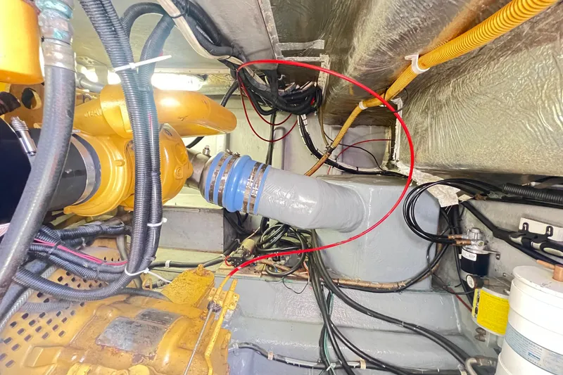 Slide: The Image of Engine room of a 1996 Riviera 4800 Sport Yacht with visible hoses and wiring. - 74