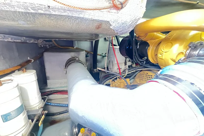 Slide: The Image of Engine room of a 1996 Riviera 4800 Sport Yacht, showcasing mechanical components and piping. - 75