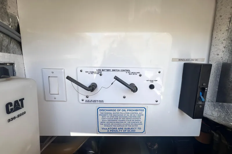 Slide: The Image of Control panel of a 1996 Riviera 4800 Sport Yacht with battery switch and oil discharge warning. - 77
