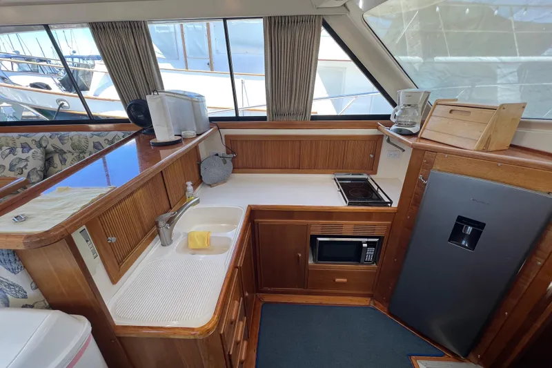 Slide: The Image of Interior of 1996 Riviera 4800 Sport Yacht kitchen with appliances and wooden cabinetry. - 8