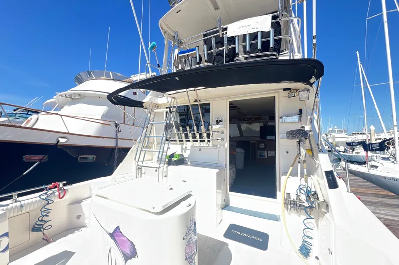 Slide: The Image of Riviera 4800 Sport Yacht 1996 docked at marina, showcasing rear deck and equipment. - 86