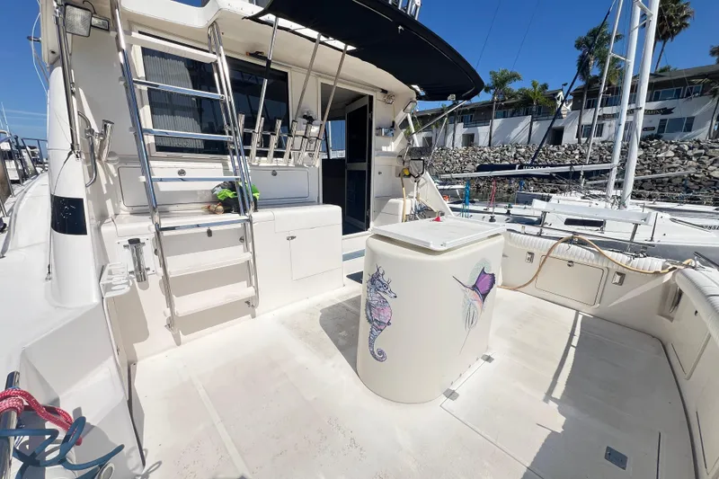 Slide: The Image of 1996 Riviera 4800 Sport Yacht deck with ladder, storage, and nautical decor. - 88