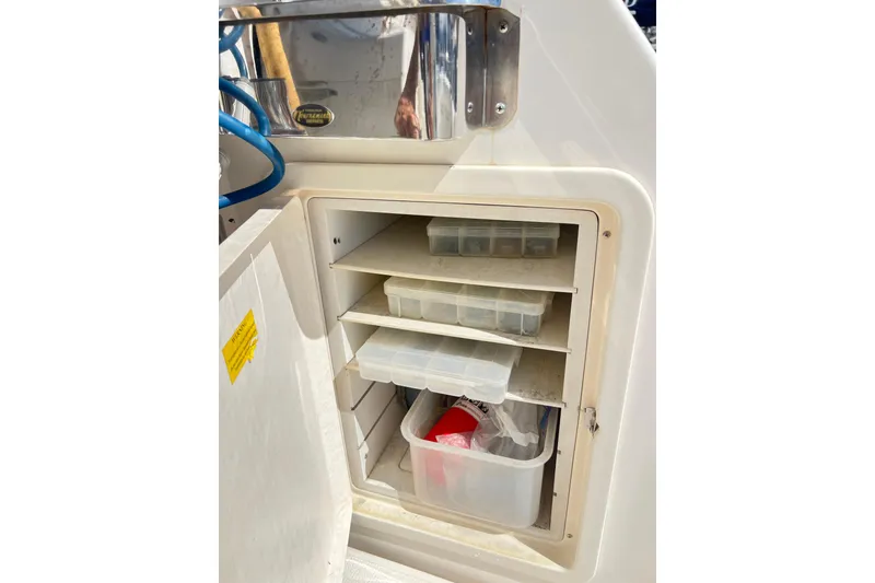 Slide: The Image of Storage compartment on a 1996 Riviera 4800 Sport Yacht with organized shelves and containers. - 90