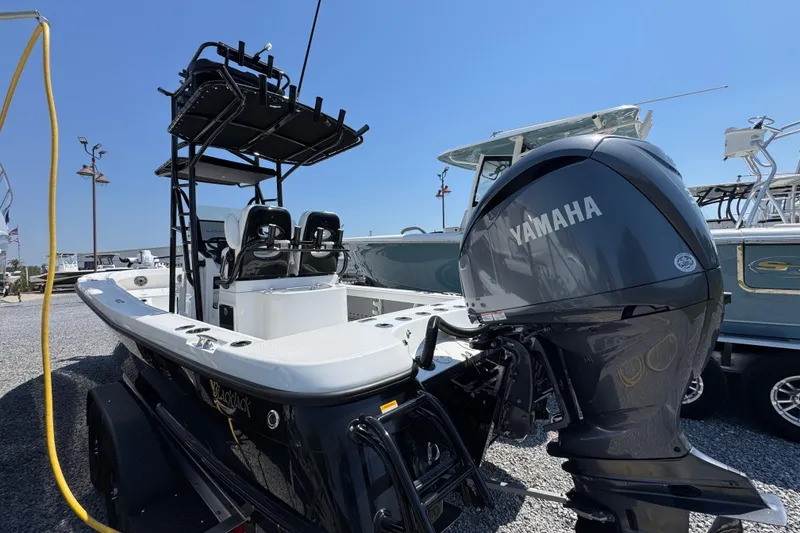 Slide: The Image of 2025 BlackJack 256 Coastal boat with Yamaha engine, parked on gravel lot. - 11