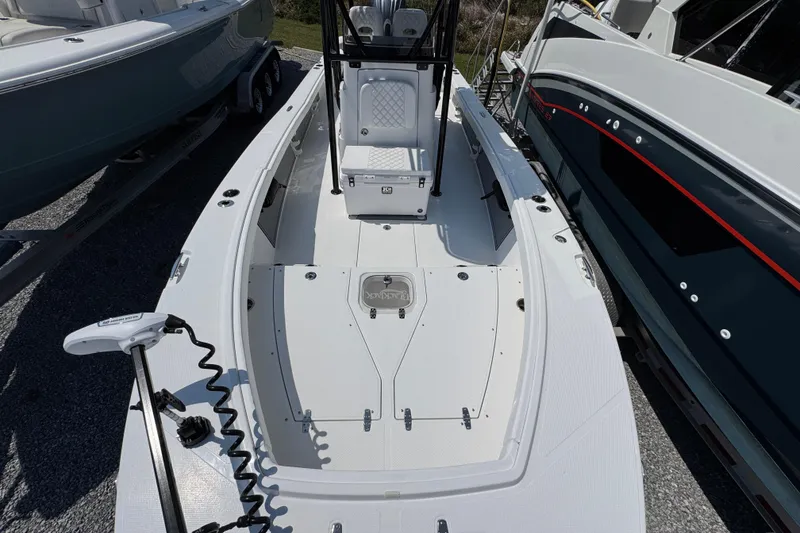 Slide: The Image of 2025 BlackJack 256 Coastal boat, white deck, parked between two other boats. - 16