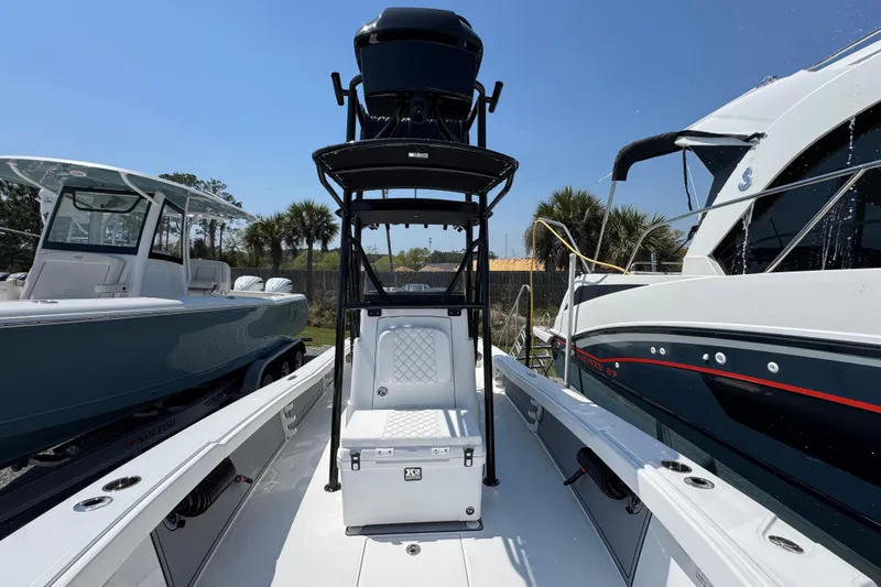 Slide: The Image of 2025 BlackJack 256 Coastal boat with T-top and seating, docked between other boats. - 18