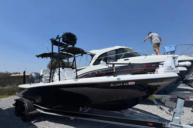 Slide: The Image of 2025 BlackJack 256 Coastal boat on trailer, parked outdoors under clear blue sky. - 2
