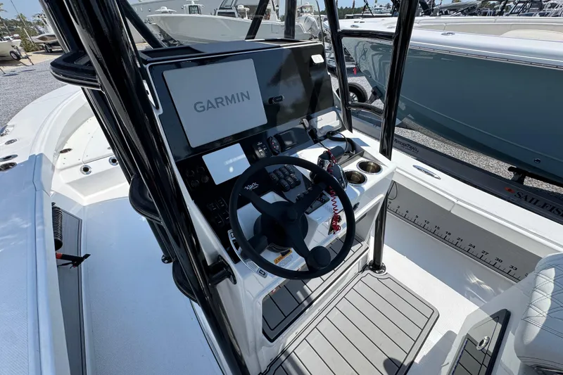 Slide: The Image of 2025 BlackJack 256 Coastal boat cockpit with Garmin navigation system and steering wheel. - 25
